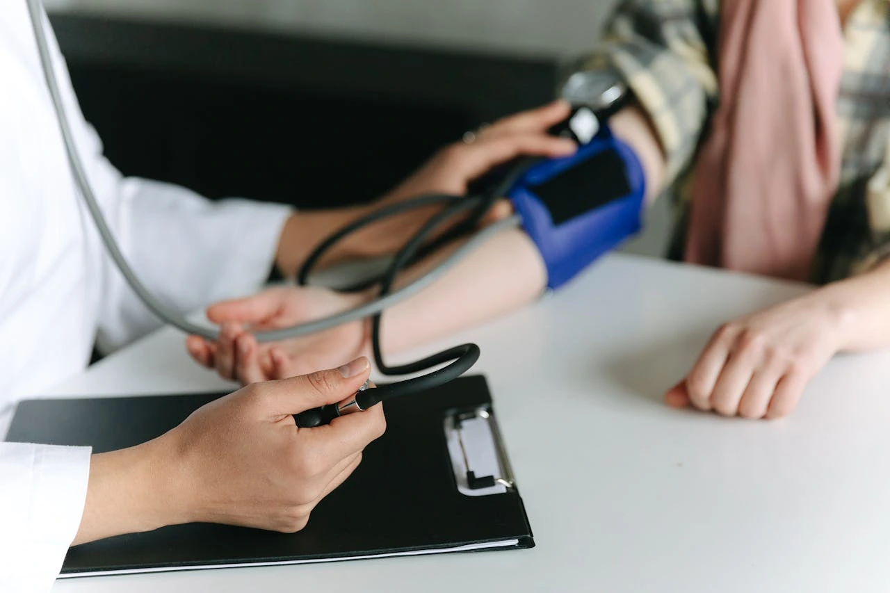 Doctor measuring patient's blood pressure with cuff on arm